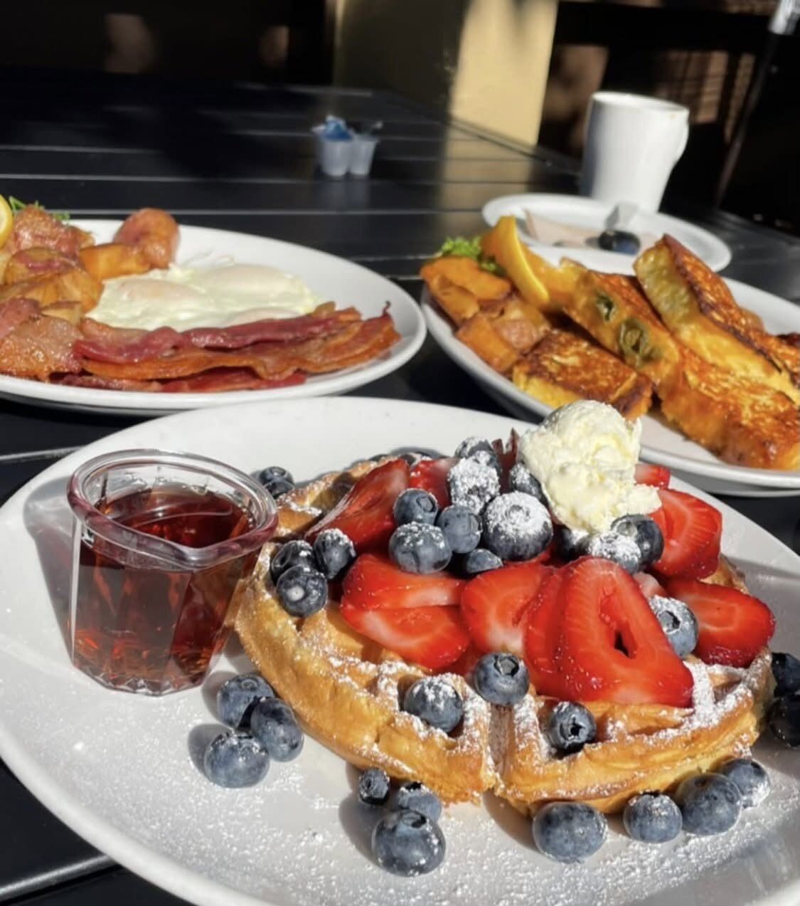 Belgian waffle with fresh berries and a full breakfast spread